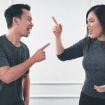 Conflict - man in gray crew neck long sleeve shirt standing beside woman in black crew neck shirt