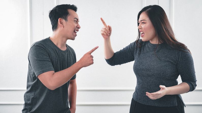 Conflict - man in gray crew neck long sleeve shirt standing beside woman in black crew neck shirt