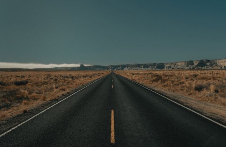 Long-Distance - black asphalt road between brown grass field under blue sky during daytime