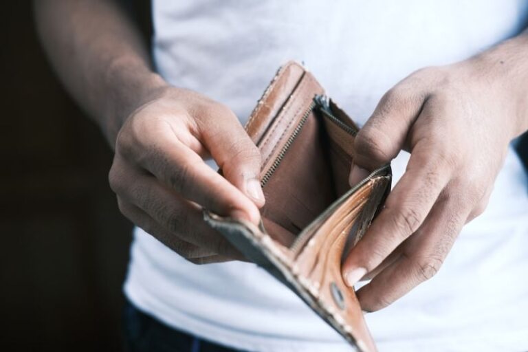 Debt - person holding brown leather bifold wallet