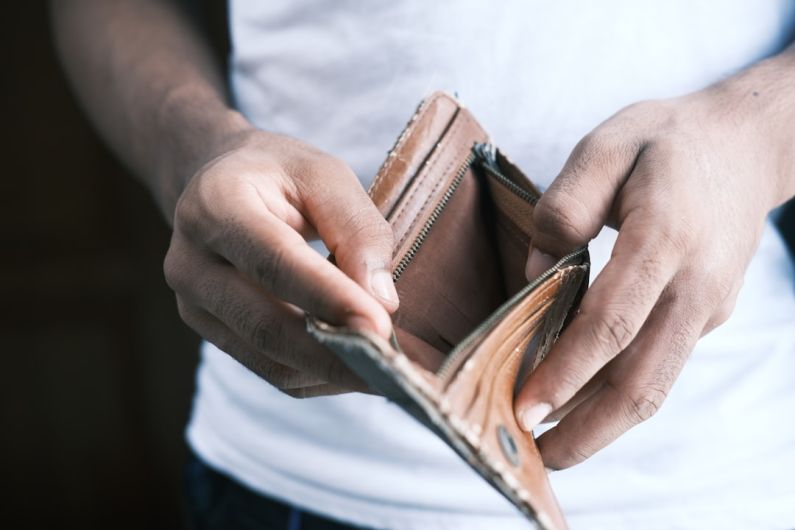 Debt - person holding brown leather bifold wallet