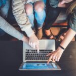 Digital Skills - three person pointing the silver laptop computer