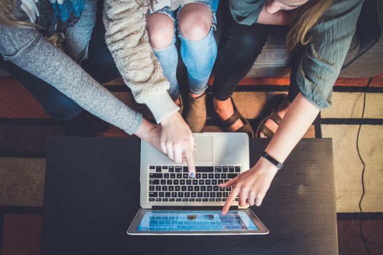 Digital Skills - three person pointing the silver laptop computer