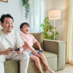 Gaming - a person and a child sitting on a couch