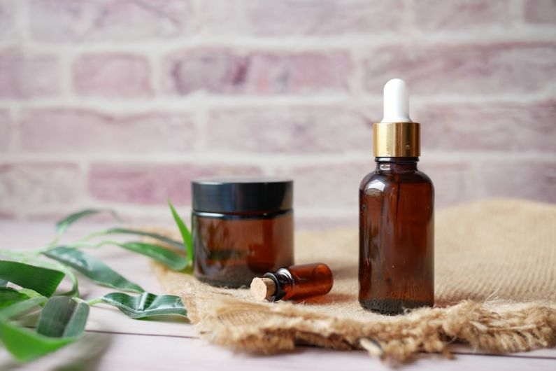 Aromatherapy - brown glass bottle on brown textile