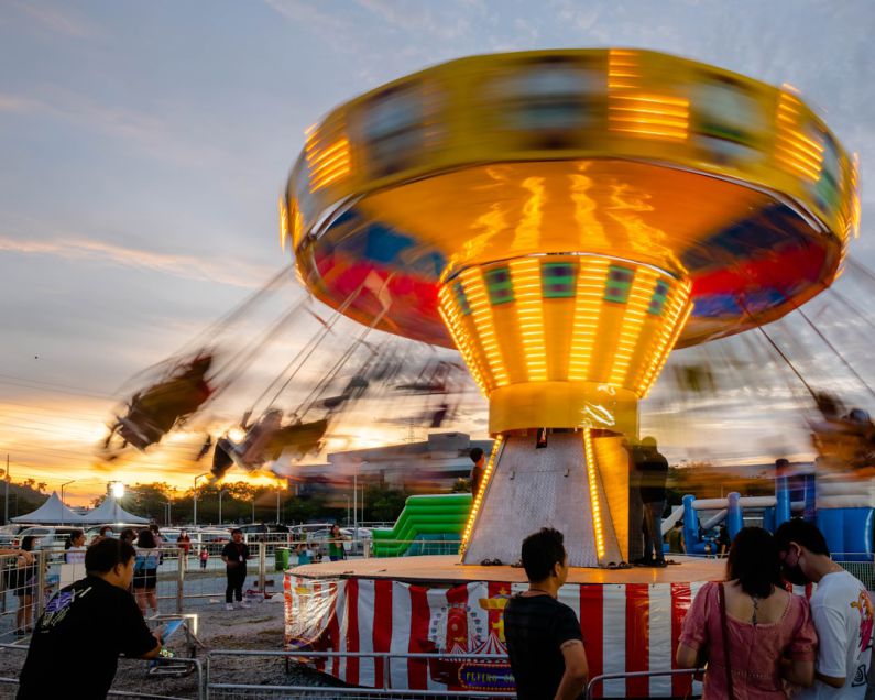 Live Performances - a carnival ride with people standing around it