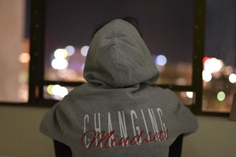 Mindset - person wearing gray and red hooded jacket facing back