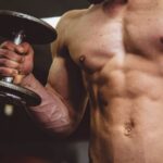 Muscle - man holding black dumbbell