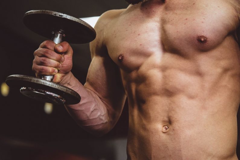 Muscle - man holding black dumbbell