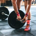 Interval Training - person locking gym plates on barbell