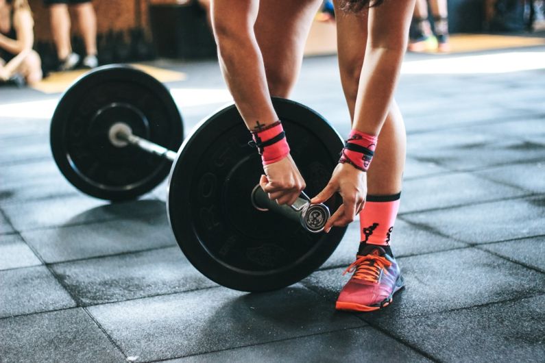 Interval Training - person locking gym plates on barbell