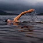 Swimming - man swimming on body of water