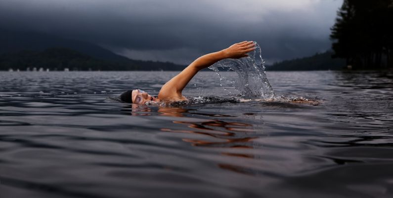 Swimming - man swimming on body of water
