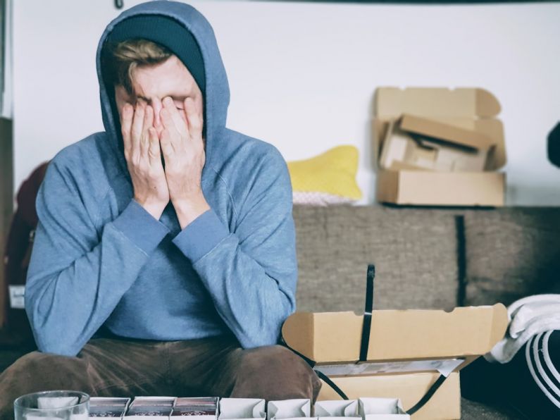 Stress - man covering face with both hands while sitting on bench