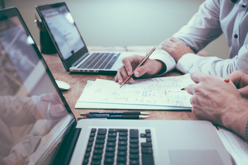 Insurance - person holding pencil near laptop computer