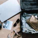 Packing - black DSLR camera near sunglasses and bag