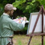 Weekend Getaway - a statue of a man holding a paintbrush and painting a picture