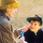 Sun Protection - boy in black hat holding blue plastic bottle