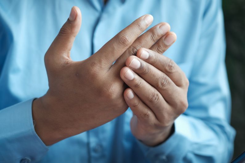 Chronic Pain - person in blue shirt showing left hand