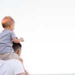 Parents - man in white shirt carrying boy