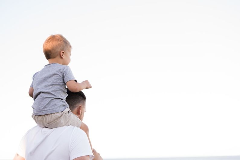 Parents - man in white shirt carrying boy